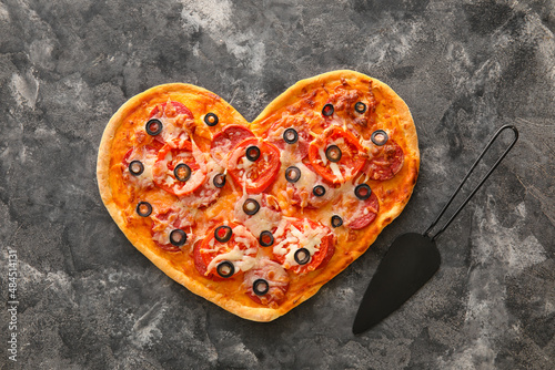 Tasty heart-shaped pizza on grunge background. Valentine's Day celebration
