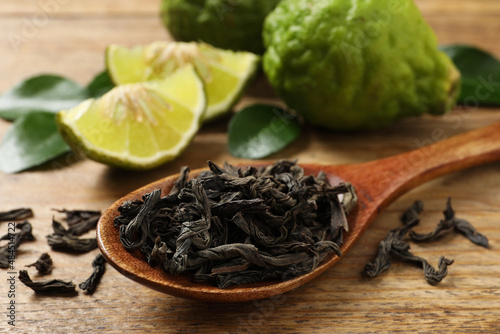 Canvas Print Dry bergamot tea leaves and fresh fruits on wooden table, closeup