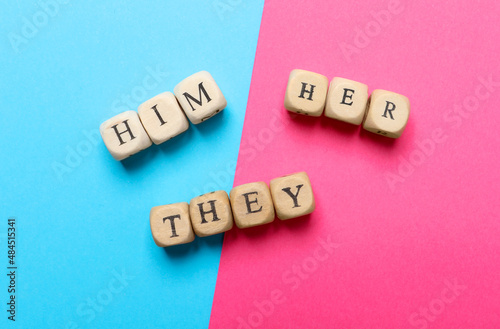 Fotografiet Gender pronouns made of wooden cubes on color background, flat lay