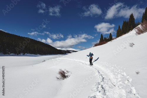 a young woman hiking in the mountains on snowshoes. © goodmanphoto