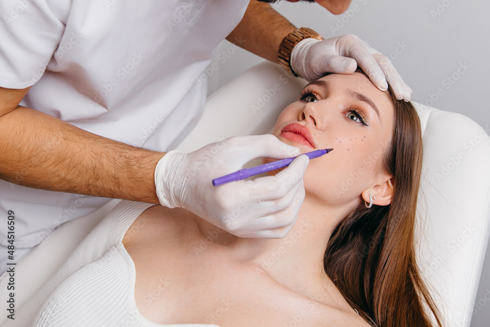Plastic surgeon making marks by pencil on patient body Plastic surgeon making marks by pencil on patient body