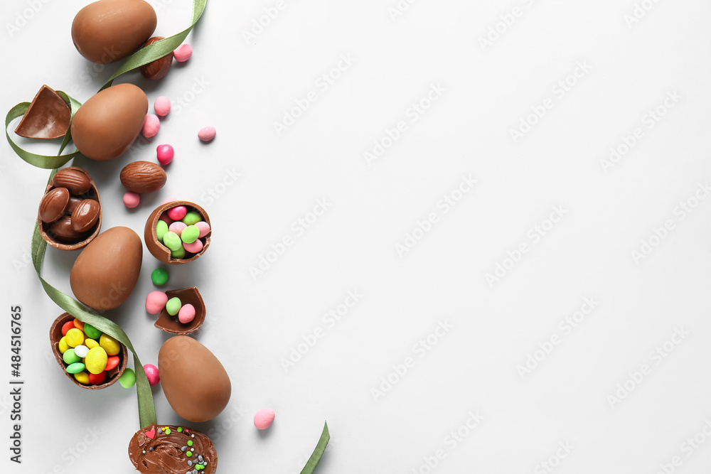 Composition with broken chocolate Easter eggs and different candies on light background