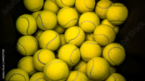 Top view of lot tennis balls in a box. Black basket of practice paddle balls © REC Stock Footage