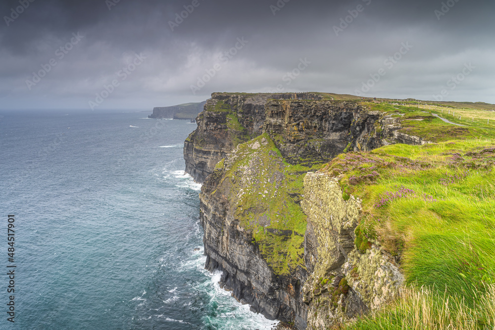 Dark, dramatic storm sky over iconic Cliffs of Moher, popular tourist attraction, UNESCO world heritage, Wild Atlantic Way, Clare, Ireland