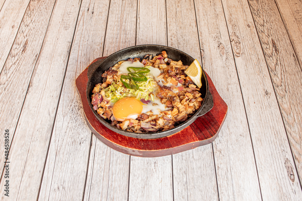 Sisig is a Filipino food of Pampanga origin. It is made with pig's head and liver, and is regularly served with hot peppers and calamansí. Sisig was invented by Lucia Cunanan Sisig is a Filipino food of Pampanga origin. It is made with pig's head and liver, and is regularly served with hot peppers and calamansí. Sisig was invented by Lucia Cunanan