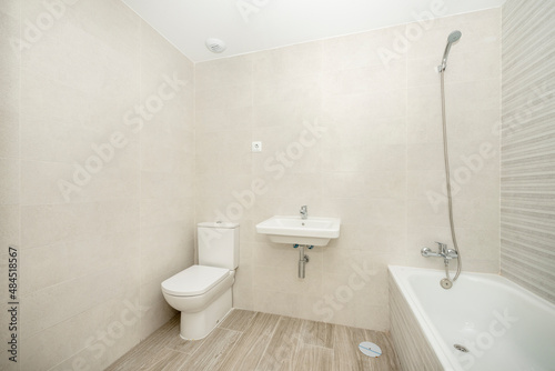 Bathroom with stoic furnishings and tiling in light cream tones