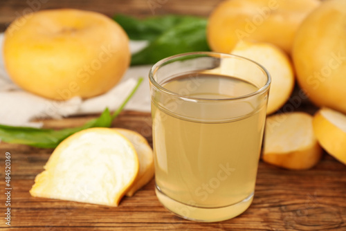 Glass of freshly made turnip juice on wooden table, closeup