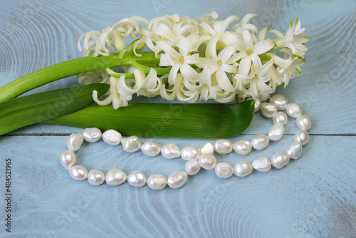 White hyacinth and pearl necklace, jewelry composition, greeting card for Valentine's Day, wedding, etc., selective focus, horizontal