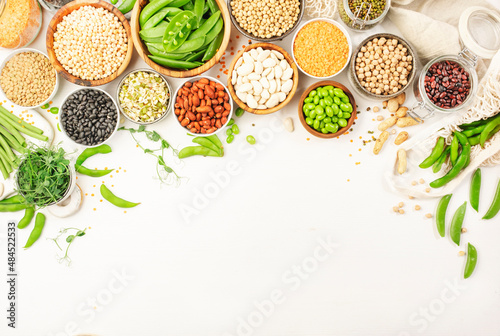 Legumes, beans and sprouts. Dried, raw and fresh, top view. Red kidney beans, lentils, mung beans, chickpeas, soybeans, edamame, green peas, Healthy, nutritious, diet food, vegan protein photo