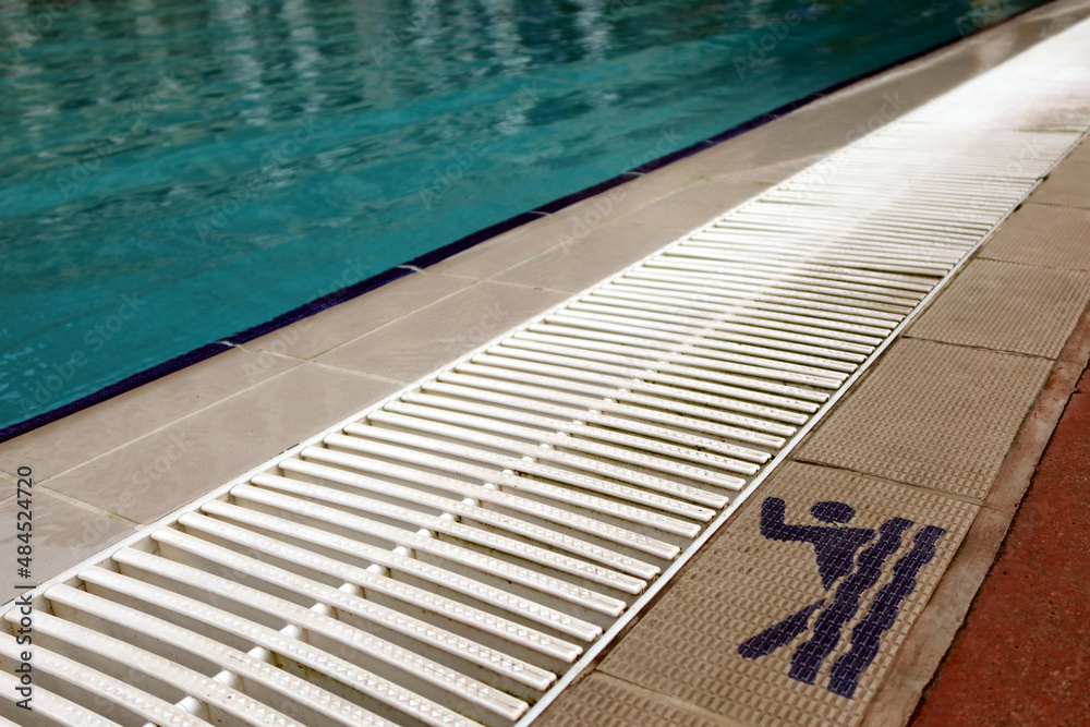 Obraz premium Sign of swimming permition at swimming pool side, with clearly blue water in the pool. Sport, recreation, swimming concept