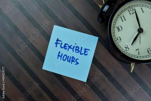 Flexible Hours write on sticky notes isolated on Wooden Table.