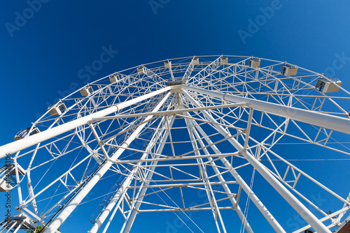 White ferris wheel on blue sky background in sunny day