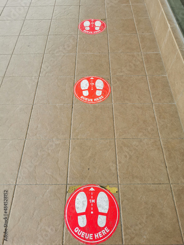 Photo of footprint  sticker sign for stand in front of restaurant. Social distancing concept. photo