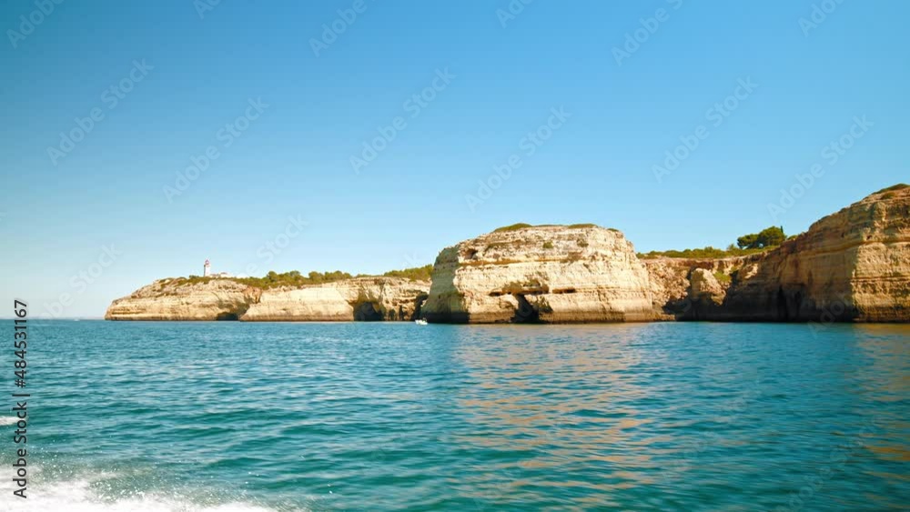 Algar de Benagil and other Coastal Caves in Algarve, Portugal from a boat. Panoramic scenic view from the sea of the rock formations and fossils by Atlantic Ocean with turquoise water and sunny day. Algar de Benagil and other Coastal Caves in Algarve, Portugal from a boat. Panoramic scenic view from the sea of the rock formations and fossils by Atlantic Ocean with turquoise water and sunny day.