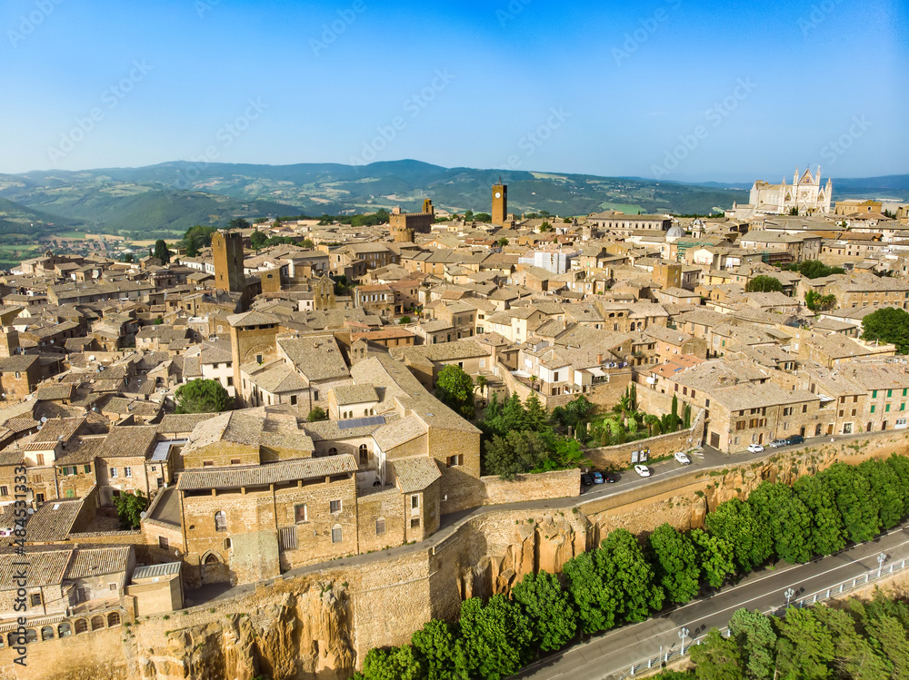 Obraz premium Aerial view of the famous Orvieto, a medieval hill town, rising above the almost-vertical faces of tuff cliffs and surrounded by its vineyards and wineries, Italy.