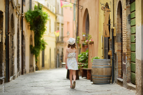 Young girl exploring medieval streets of picturesque resort town Bolsena, situated on the shores of Italy's largest lake, Lago Bolsena, Italy. © MNStudio