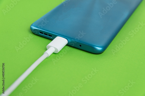 Blue cell phone connected to USB cable type C - Charging