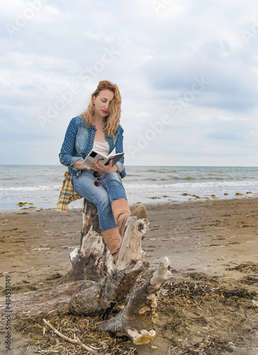 beautiful happy woman at the seaside reading a book