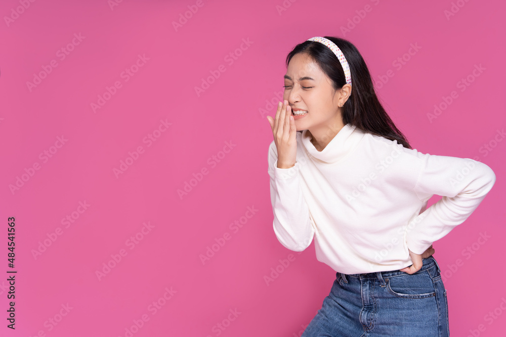 Asian woman was sick with stomach ache and standing isolated pink background Asian woman was sick with stomach ache and standing isolated pink background