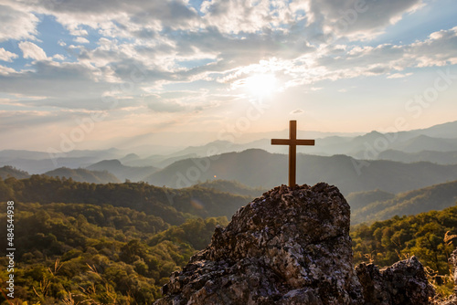 Papier peint Crucifix symbol on top rock  mountain with bright sunbeam on the colorful sky background