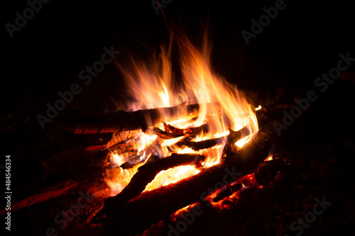 Defocused fire background, blurred white and orange fire flames in the night texture, red shining coals