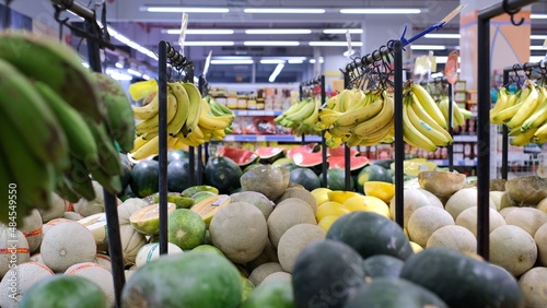 Panorama of exotic fruits market place full of fresh row bananas, watermelons, coconuts, mangos, melons