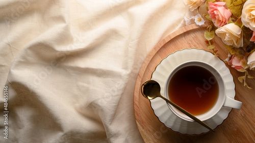 Feminine vintage tea table setting with ceramic tea cup on wooden tray