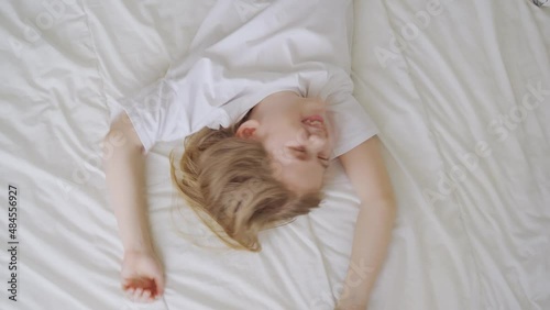 view top. a little girl laughs with tickling on the bed. games of children photo