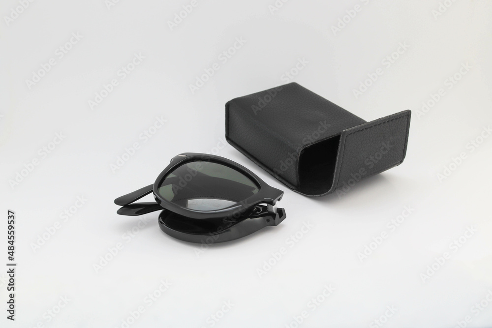 Folding wayfarer sunglass black and sunglasses bag isolated on white background closeup.