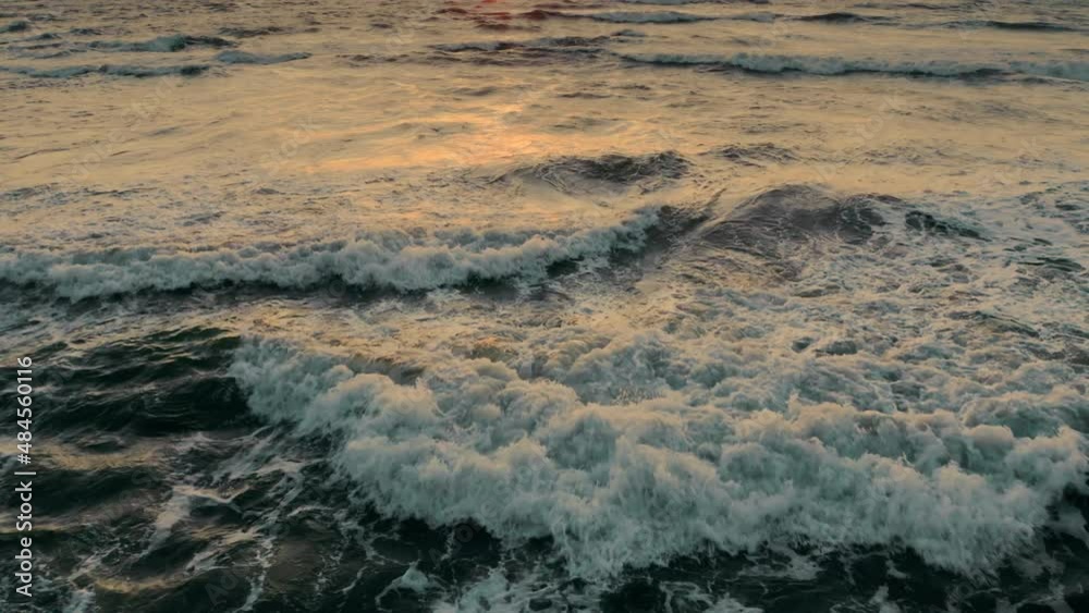 Aerial flight over dark ocean waves in the rays of the setting sun. An alarming tense dark frame with a swaying sea before a storm in the evening. Summer time. the texture of dark ocean water. Aerial flight over dark ocean waves in the rays of the setting sun. An alarming tense dark frame with a swaying sea before a storm in the evening. Summer time. the texture of dark ocean water.