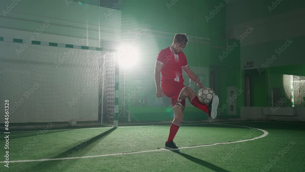 Slow motion, professional football player performs tricks with a soccer ball, balances and throws the ball, performs a handstand and scores a goal. Slow motion, professional football player performs tricks with a soccer ball, balances and throws the ball, performs a handstand and scores a goal.