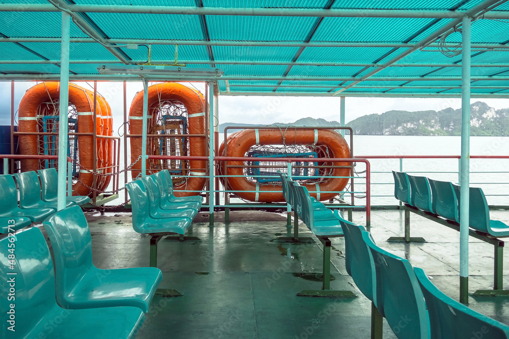 Fototapeta premium Orange inflatable lifeboats on ferry deck for emergencies and maritime accidents. Rescue boat, raft on the roof of a ferry. Life boats on big ship on ocean sea cruise ship.Transportation and safety.