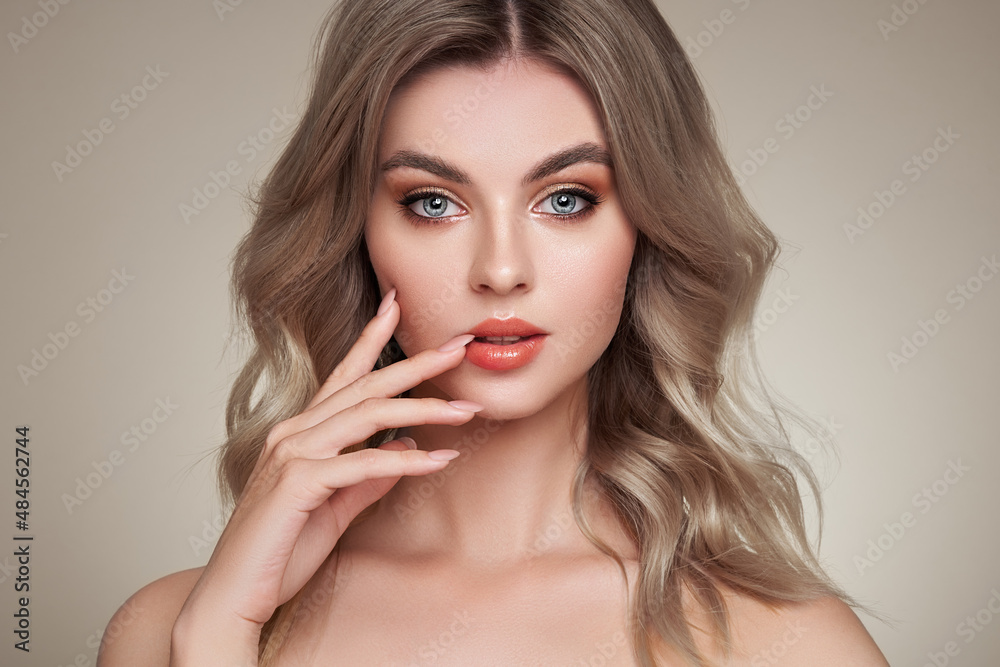 A beautiful young woman with shiny wavy blonde hair. Model with healthy skin, close up portrait. Cosmetology, beauty and spa A beautiful young woman with shiny wavy blonde hair. Model with healthy skin, close up portrait. Cosmetology, beauty and spa