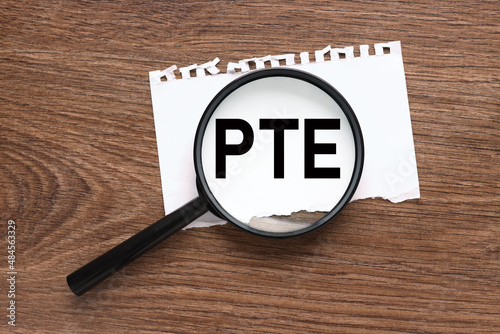 Pearson Tests of English PTE Words on card on magnifier glass business concept photo