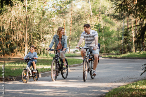 Happy family having bicycle ride in park together