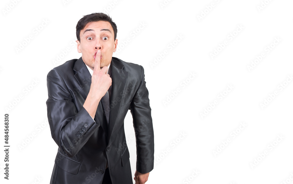 Man in formal suit covering mouth with finger