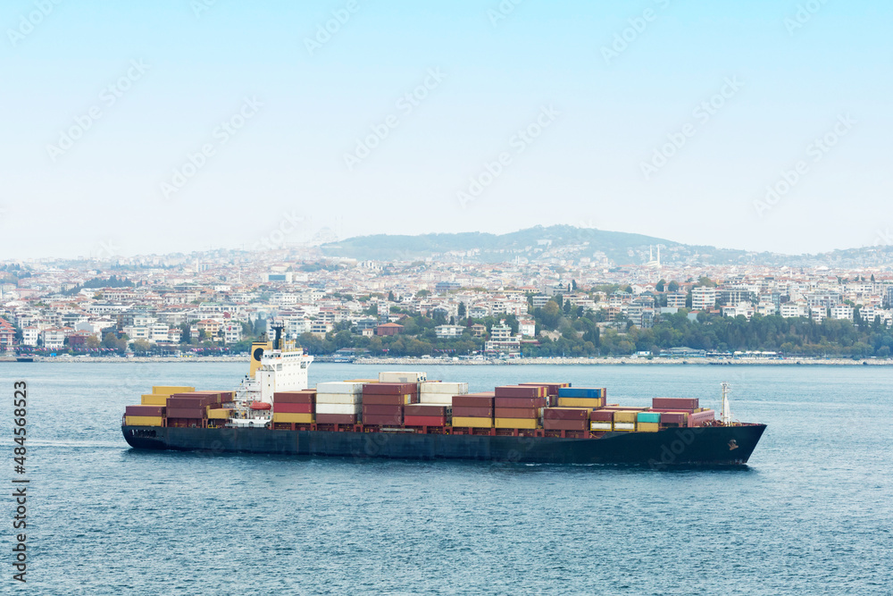 Cargo Container Ship at Sea. A large ship transporting numerous cargo containers through istanbul Bay, Turkey.