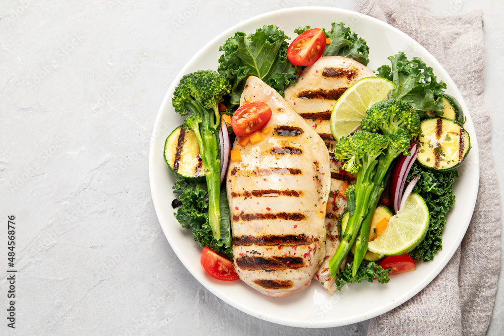Grilled chicken with vegetables on light background. Grilled chicken with vegetables on light background.