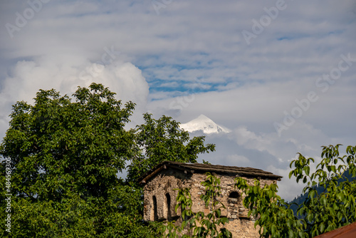 Panoramic view on the Svan towers in Mestia, a highland townlet, located in the High Caucasus, Svaneti Region in Georgia. Snow-peaked mountains covered by clouds in the background. Wanderlust.  photo