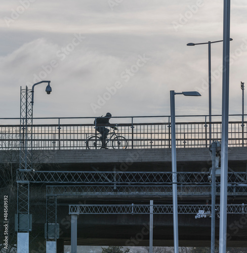 Bicycler on a bridge with pools with lamps and cameras a cold sunny winter day in Stockholm