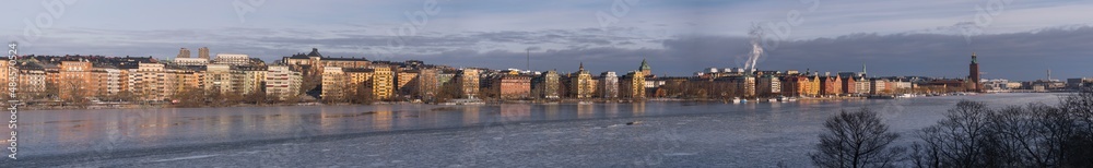 Panorama view over the pier and houses at the district Kungsholmen at the waterfront Norrmälarstrand and an icy bay Riddarfjärden a cold and sunny winter day in Stockholm