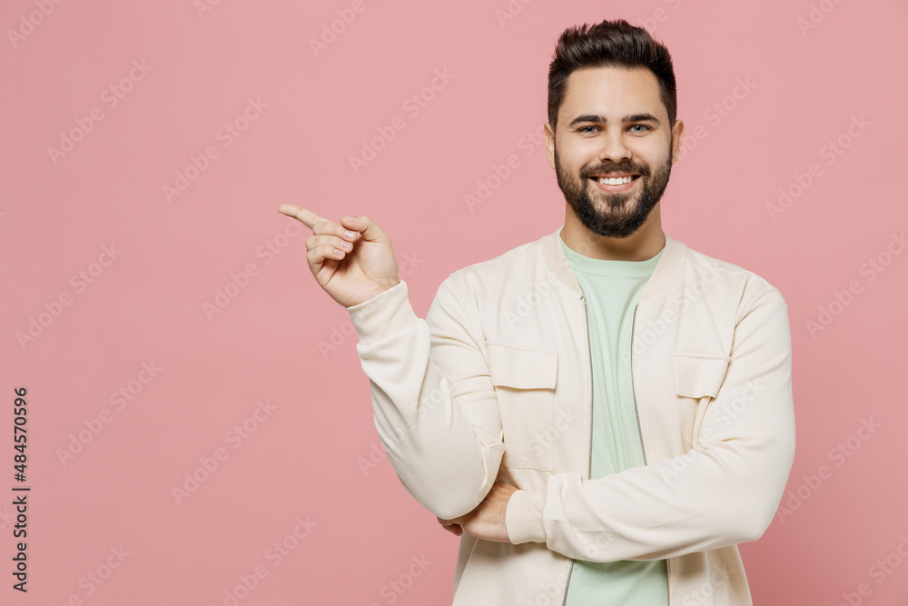 Young smiling happy caucasian man 20s wearing trendy jacket shirt point index finger aside on copy space area mock up workspace isolated on plain pastel light pink background People lifestyle concept Young smiling happy caucasian man 20s wearing trendy jacket shirt point index finger aside on copy space area mock up workspace isolated on plain pastel light pink background People lifestyle concept