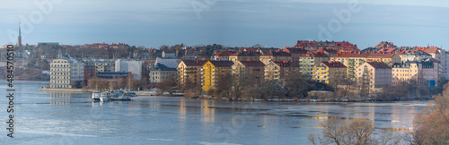 Panorama view over the island Lilla Essingen at an icy bay of the lake Mälaren with apartment houses, jetties and bridges a cold sunny winter day in Stockholm © Hans Baath
