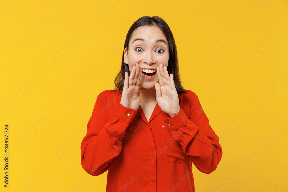 Promoter excited vivid young woman of Asian ethnicity 20s years old wears orange shirt scream hot news about sales discount with hands near mouth isolated on plain yellow background studio portrait. Promoter excited vivid young woman of Asian ethnicity 20s years old wears orange shirt scream hot news about sales discount with hands near mouth isolated on plain yellow background studio portrait.