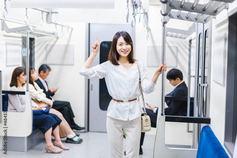 電車でポイントを指差す若い女性 電車でポイントを指差す若い女性