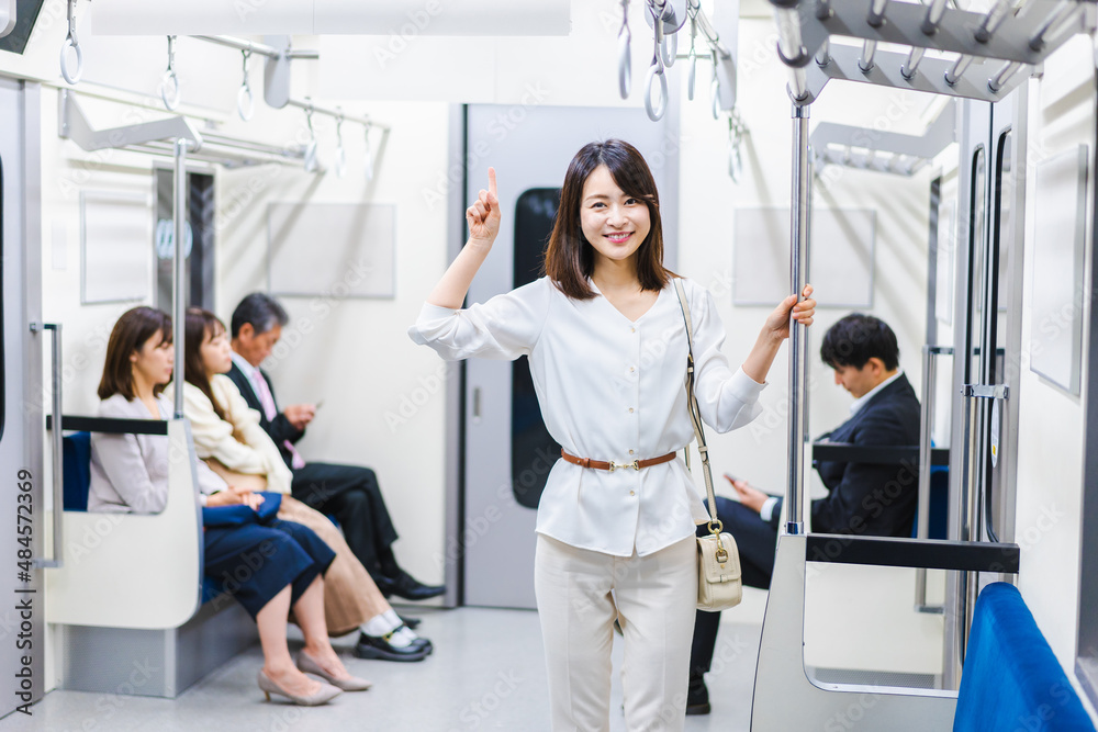 電車でポイントを指差す若い女性 電車でポイントを指差す若い女性