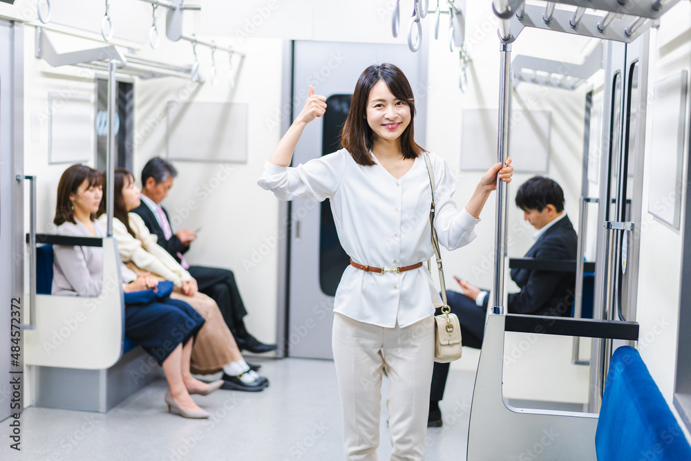 電車でポイントを指差す若い女性 電車でポイントを指差す若い女性