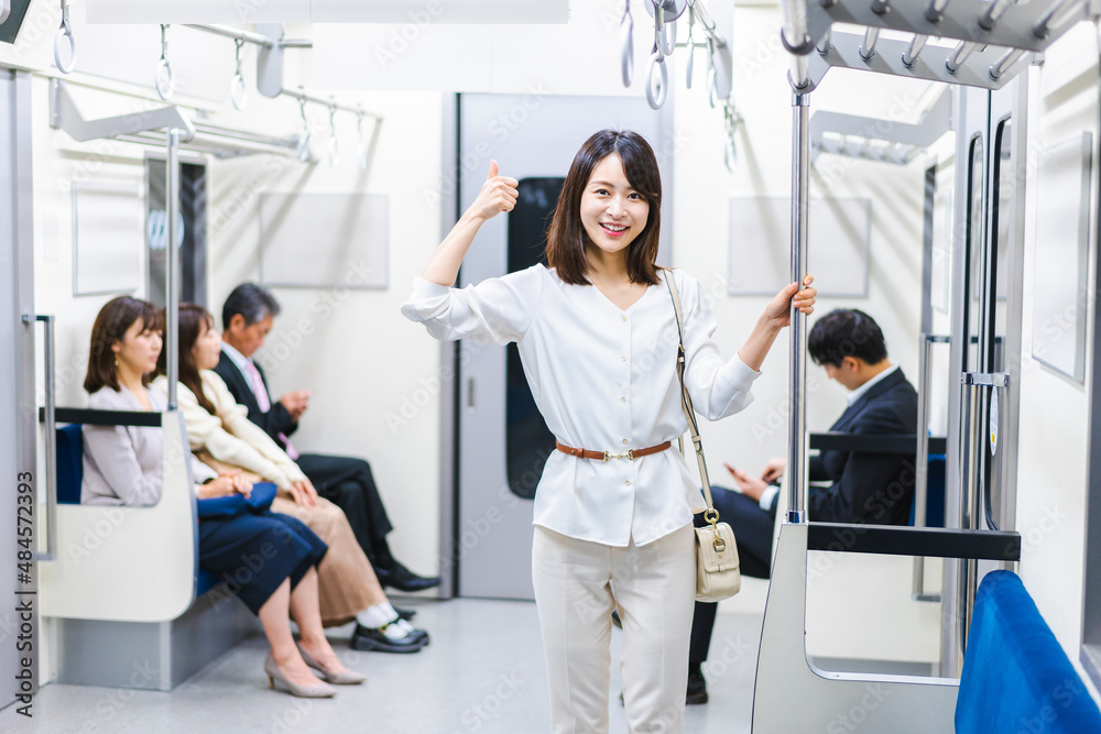電車でポイントを指差す若い女性 電車でポイントを指差す若い女性