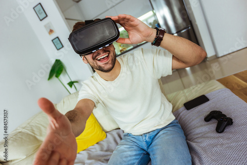 Man wearing virtual reality goggles in the living room.