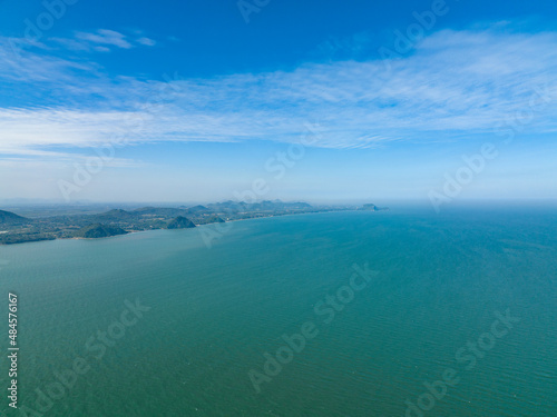 lonely faraway, the empty ocean seperate half frame water and cloud blue sky with little mountain in left side